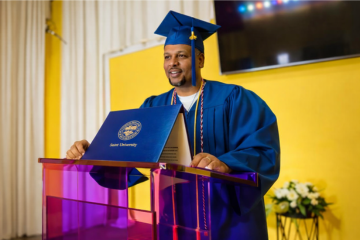 Pastor speaking at pulpit in graduation gown